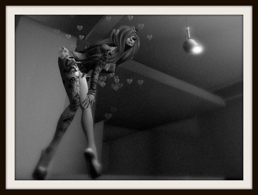 black and white photo. low camera angle looking up FairY's right leg which has a floral tattoo running up the entire length of her leg. FairY bends over at the waist