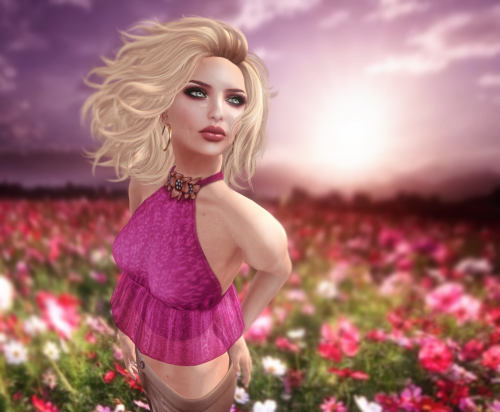 Rainy wearing a pink halter top in a field of pink flowers against an afternoon pink sky