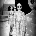 Black & White photo of Vaneeesa Blaylock standing with a series of "tin people" who have hearts etched into their bodies