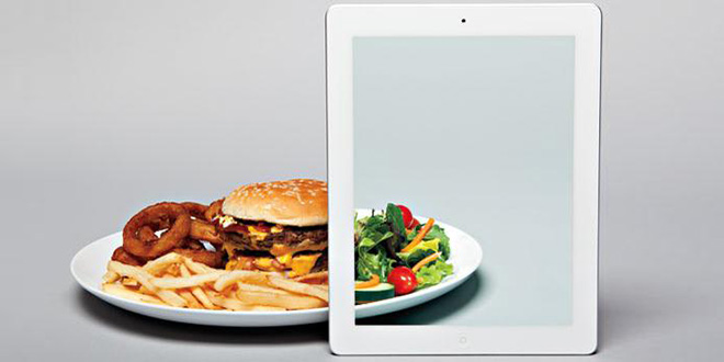 Image of greasy hamburger plate being transformed into a healthy salad by an iPad augmented reality display