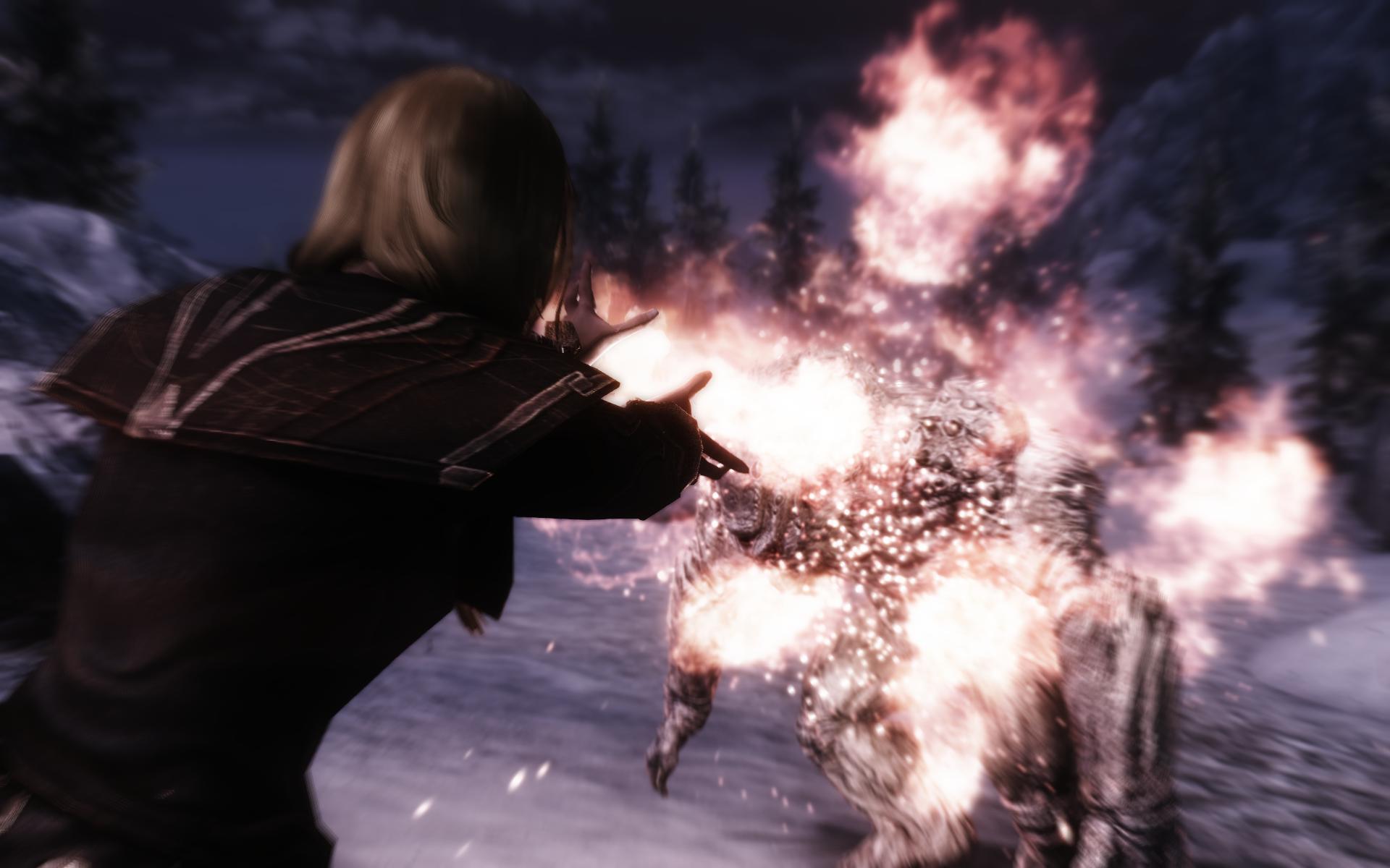 A mage character in Skyrim emits a range of flames out of her hands, setting a frost troll on fire