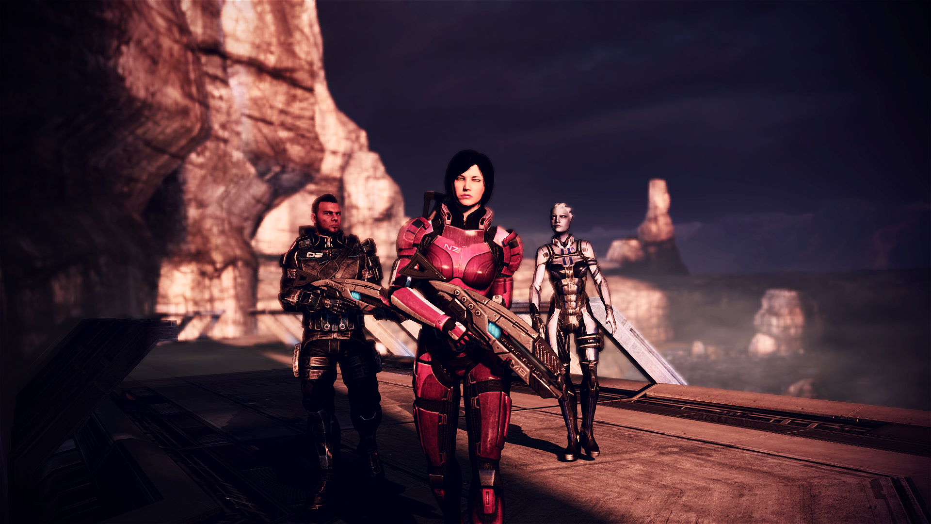 Three armed adventurers (a black-haired women, a man and a blue skinned female alien) walk on a desert planet.