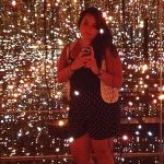 Jacque Donaldson standing in a "mirror room" filled with tiny twinkle lights