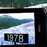 Augmented Reality Image: in Alaska a hand holds an iPhone in front of a sign showing 1978 ice levels and the iPhone is able to Augment the visual scene with ice levels of the past