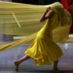 Image from Sarah Elgart's FlyAway Home: Dancers in Yellow or Red fabric move across the frame