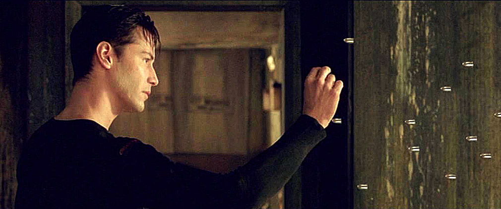 Frame from The Matrix where Neo says "No," stops the bullets heading toward him, and holds one between his fingers and examines it.