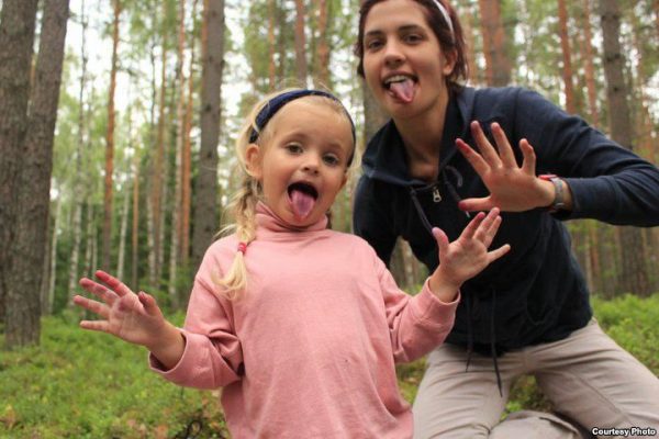 Nadezhda Tolokonnikova and daughter Gera making faces in a forest. Their hands are slightly stained, as if picking blueberries.