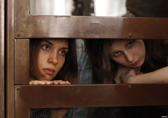 Letters to Nadya and Maria in prison. Photograph from Pussy Riot trial in Russia. Nadya Tolokno and Maria Alyokhina peek through the small opening in the glass cell they were kept in during the trial.
