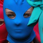 Pussy Riot Solidarity Parade. Photo of 3 women in brightly colored ski masks.