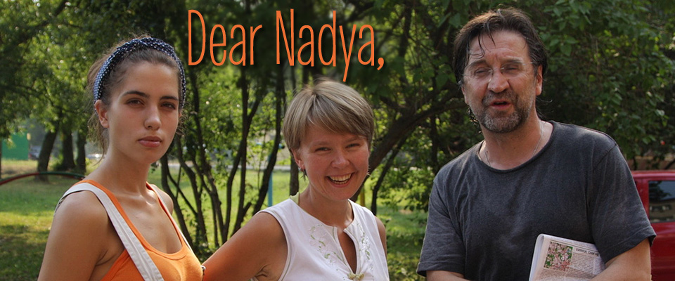 Dear Nadya. Nadya Tolokno. Nadezhda Andreyevna Tolokonnikova. Наде́жда Андре́евна Толоко́нникова. Nadya Tolokno with 2 friends in a wooded area. Tolokno wears an orange top and white overalls. Her hair is up in a blue bandana. The friends smile for the camera, yet Tolokno seems more pensive.